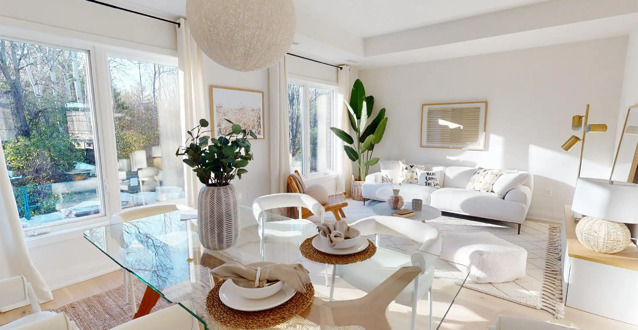 Thumbnail for Wider shot of the living and dining room with dining table in foreground and large bright windows